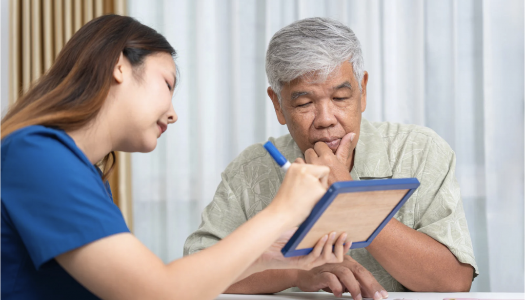doctor and older Asian man reviewing cognitive results on tablet