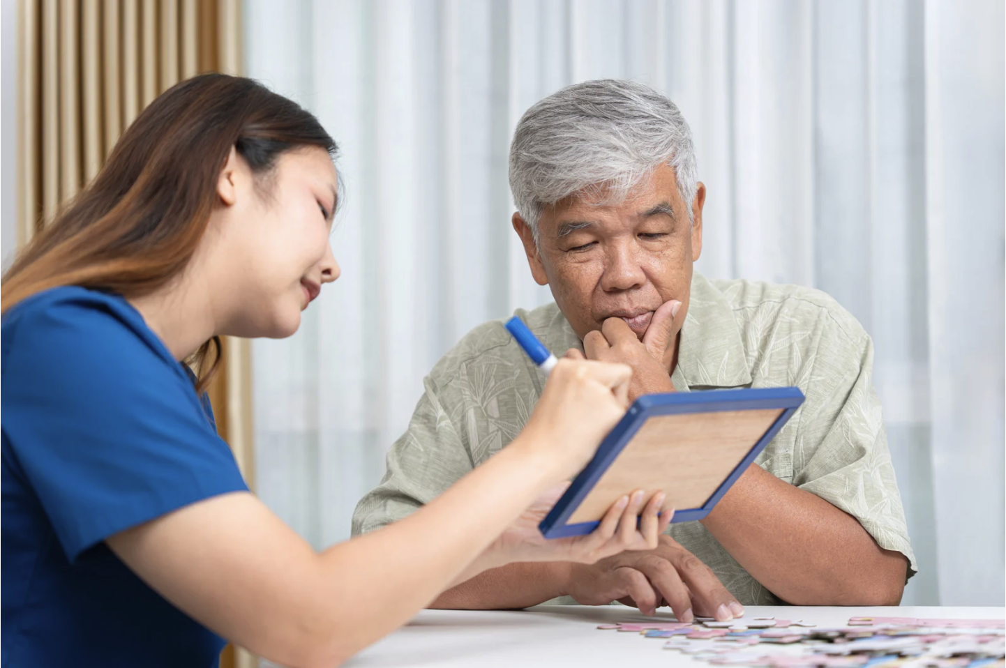 doctor and older Asian man reviewing cognitive results on tablet