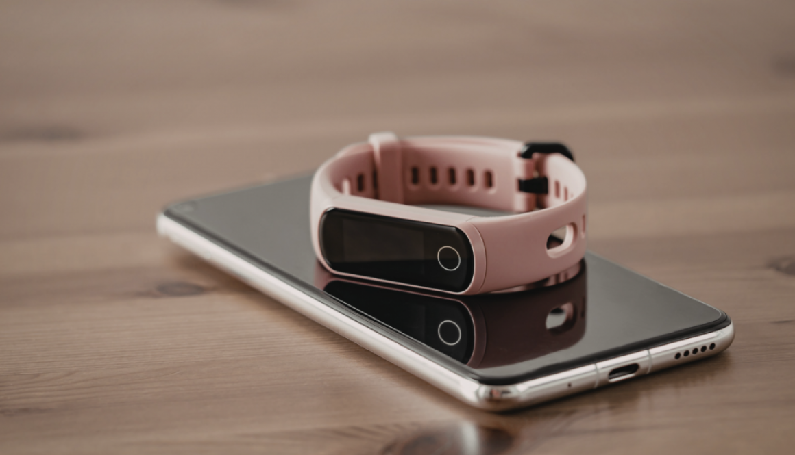 iPhone and Fitbit on a wooden surface