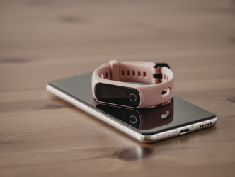 iPhone and Fitbit on a wooden surface
