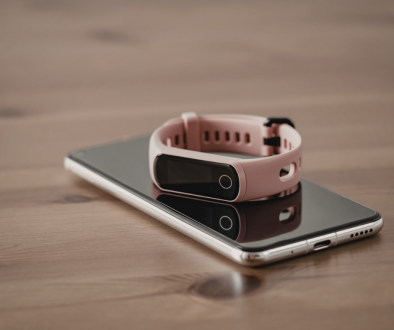 iPhone and Fitbit on a wooden surface