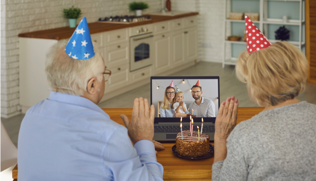 Two older adults celebrating a birthday with family via video call