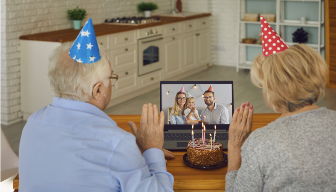 Two older adults celebrating a birthday with family via video call