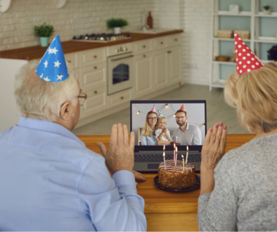 Two older adults celebrating a birthday with family via video call