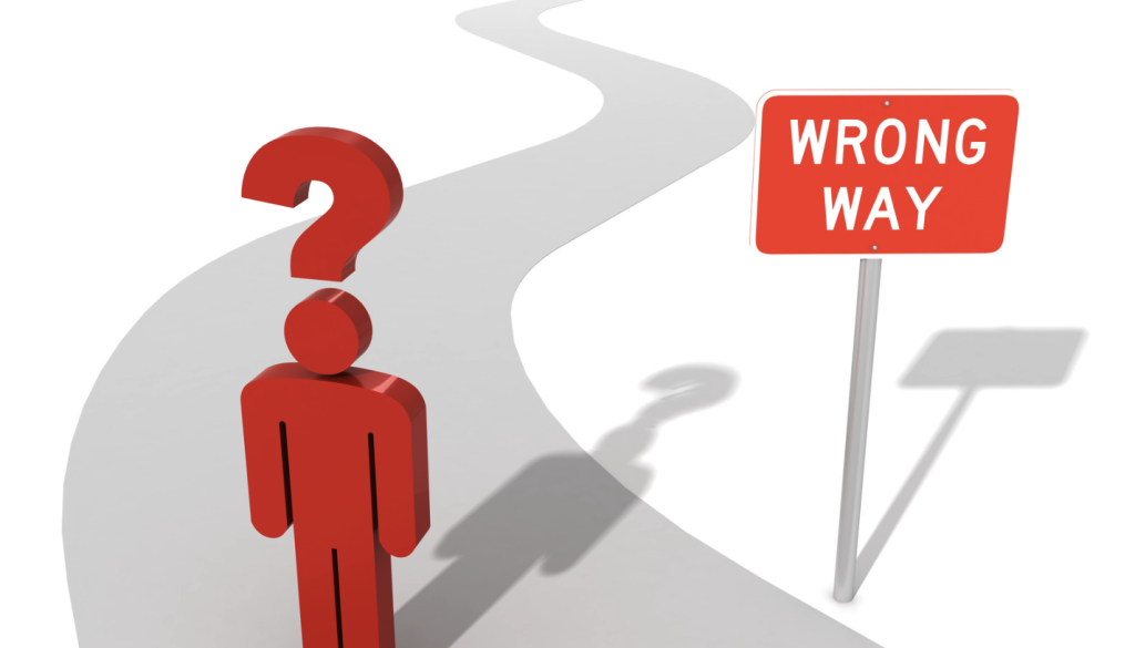 image of a stick figure man with a question mark above his head on a road marked with a 'wrong way' sign