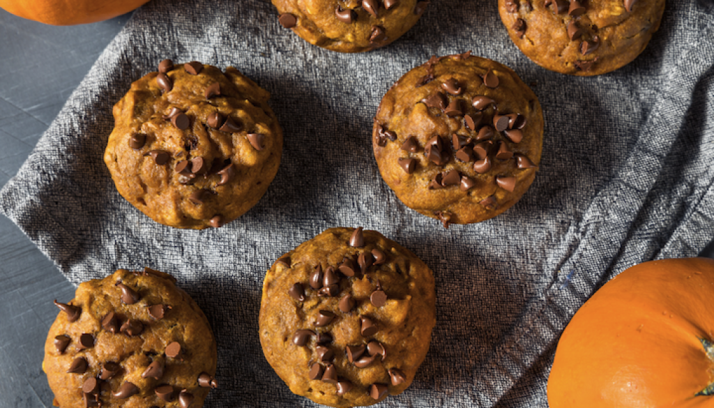 chocolate chip pumpkin muffins on a gray linen cloth