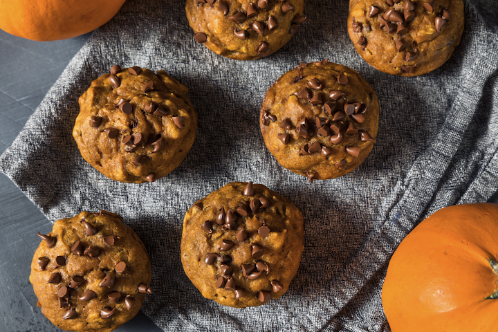 chocolate chip pumpkin muffins on a gray linen cloth